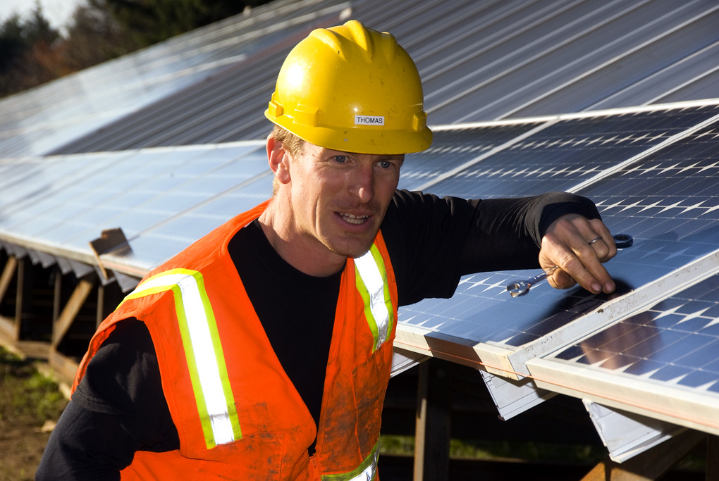 An installation crew fitting solar panels on a roof